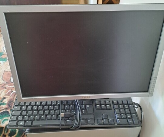 Komputer Dell z monitorem Dell, klawiatura oraz głośniki. 